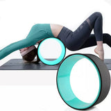 Woman using yoga wheel for back stretching on exercise mat, SportQ fitness equipment