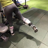 Woman using ankle strap cable attachment for leg workout in gym, SportQ fitness equipment